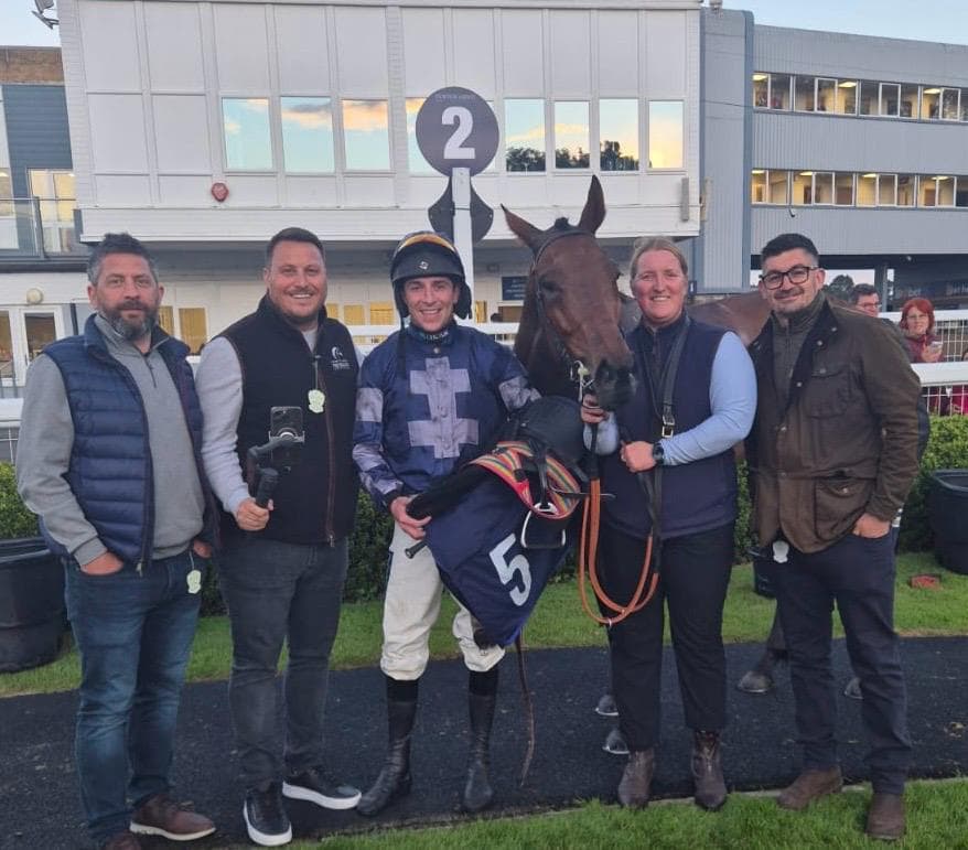 Racing connections, a jockey and their horse posing together at the racecourse